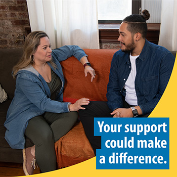 Two people seated on a living room couch, talking. The text reads, “Your support could make a difference.” 