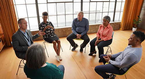 A group of Veterans sitting in a circle engaging in a group discussion