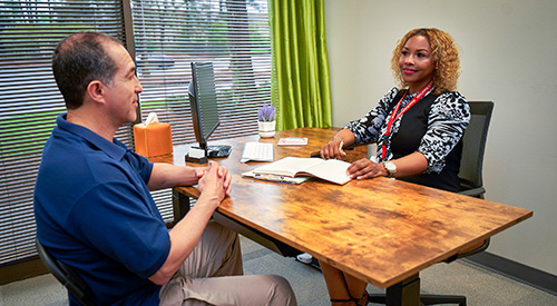 A Veteran sitting down and discussing their mental health with a VA provider.