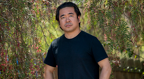 A Veteran standing on a nature trail and looking into the camera.