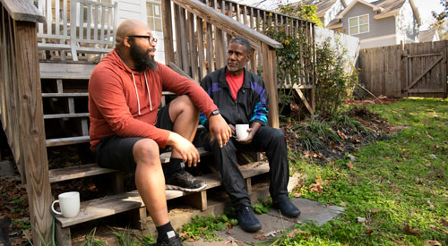 Two Veterans sitting and talking on porch.