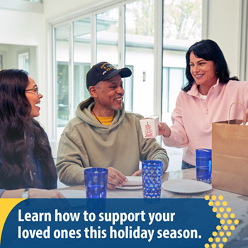 A Veteran at the kitchen table with two friends. The text reads, “Learn how to support your loved ones this holiday season.”